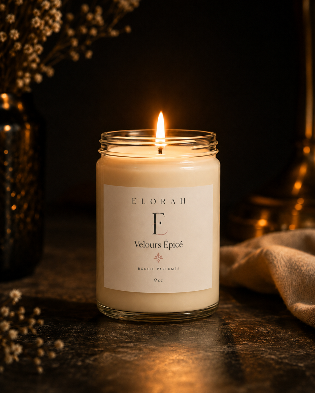 Velours Épicé comfort spice candle lit on a cozy styled table - Elorah & Co